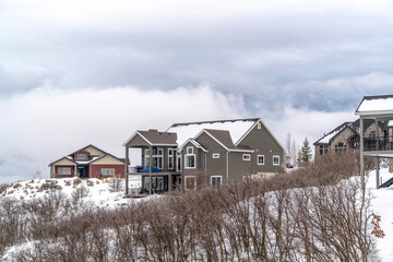 Canvas Print - Homes on hill top covered with snow in winter against background of cloudy sky