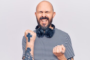 Sticker - Young handsome man listening to music using headphones celebrating surprised and amazed for success with arms raised and eyes closed