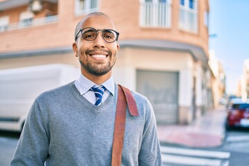 Wall Mural - Young african american businessman smiling happy walking at the city.