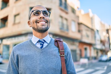 Wall Mural - Young african american businessman smiling happy walking at the city.