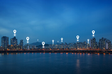 Wall Mural - Map pin icons on Seoul cityscape at dusk. Lit residential district and bridge along the Han River in Seoul, South Korea, at night. Copy space.