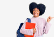 © Krakenimages.com - Young african american girl wearing student backpack holding book smiling happy pointing with hand and finger to the side