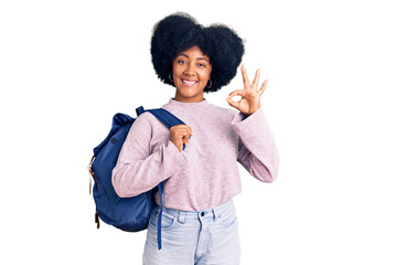 Wall Mural - Young african american girl holding student backpack doing ok sign with fingers, smiling friendly gesturing excellent symbol