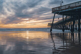 Fototapeta Zachód słońca - Pismo Beach, California/USA - January 1, 2021  Pismo Beach sunset. Wooden pier, a famous touristic attraction, wide sandy beach, Pacific ocean, and beautiful cloudy sky