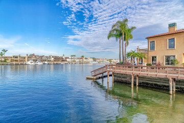 Houses and docks bordering the sea under cloudy blue sky in Huntington Beach