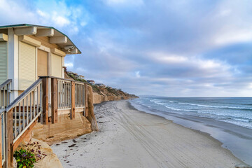 Beach house overlooking the ocean and cloudy blue sky in San Diego California