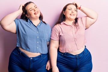 Wall Mural - Young plus size twins wearing casual clothes smiling confident touching hair with hand up gesture, posing attractive and fashionable