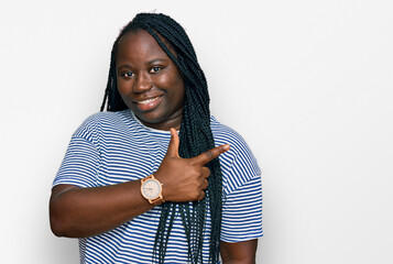 Sticker - Young black woman with braids wearing casual clothes cheerful with a smile of face pointing with hand and finger up to the side with happy and natural expression on face