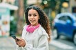 © Krakenimages.com - Beautiful hispanic girl smiling happy using smartphone and headphones at the city.