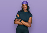 Fototapeta  - Young african american woman wearing sportswear happy face smiling with crossed arms looking at the camera. positive person.