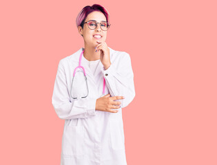 Sticker - Young beautiful woman with pink hair wearing doctor uniform looking confident at the camera with smile with crossed arms and hand raised on chin. thinking positive.