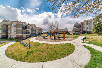 Wall Mural - Apartment houses and kids playground on a sunny day view with cloudy blue sky