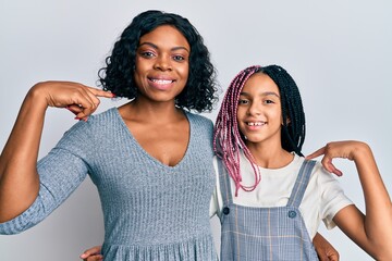 Sticker - Beautiful african american mother and daughter wearing casual clothes and hugging looking confident with smile on face, pointing oneself with fingers proud and happy.