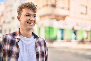 Young caucasian man smiling happy standing at the city.