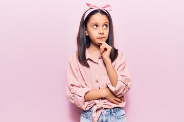 Wall Mural - Beautiful child girl wearing casual clothes with hand on chin thinking about question, pensive expression. smiling and thoughtful face. doubt concept.