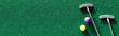 © Julia - Mini golf clubs and balls on putting green web banner with copy space