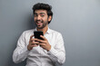 © IndiaPix - A YOUNG EXECUTIVE HAPPILY LOOKING AT CAMERA WHILE USING MOBILE PHONE