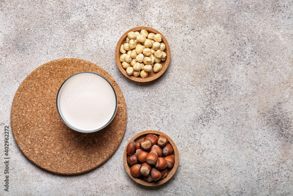 Glass of hazelnut milk on light background