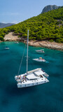 Fototapeta Big Ben - Catamaran sailing in blue, turquoise water in Greece, beautiful catamaran next to the coast during summer holiday, view from drone
