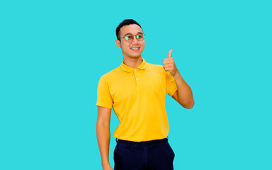 Young handsome asian man over isolated blue light background smiling looking to the camera showing  thumbs up