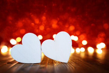 Wall Mural - Valentine's day concept. White hearts over red shiny background