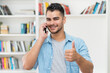 © Daniel Ernst - Happy latin american hipster man talking at mobile phone