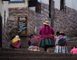 Indigenous quechua women in traditional colorful handwoven textile clothing dress costume walking in Cusco Peru