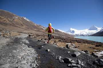 Woman trail runner cross country running in high altitude winter nature