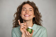© Rido - Beautiful smiling woman applying facial cream from green jar