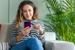 © dragonstock - Young woman holding smartphone with credit card for pay online shopping e-commerce