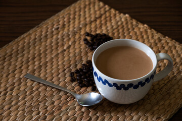 Hot coffee and coffee beans on the wooden table