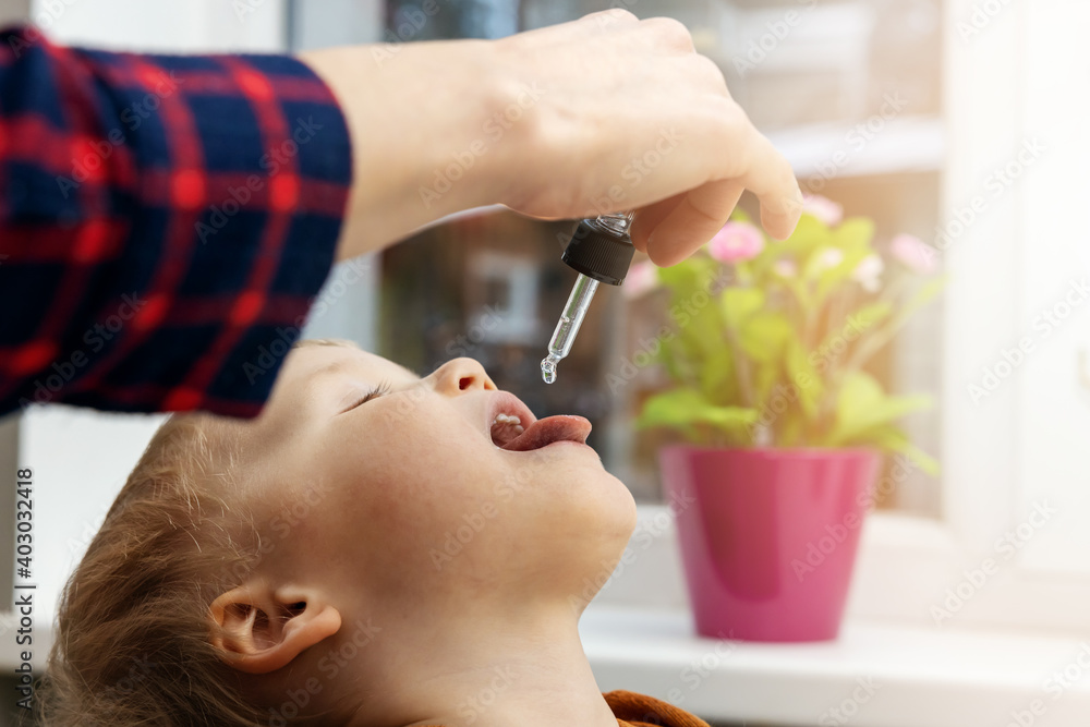 mother giving vitamin drops with dropper to her child. dietary supplements for kids - obrazy, fototapety, plakaty 