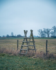 Wall Mural - Staircase over electric fence in a pasture during winter in southern Sweden