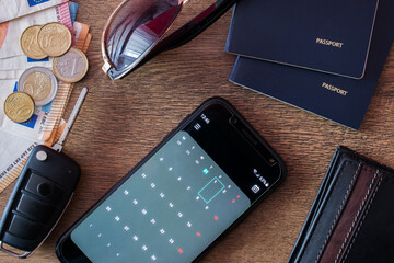 Travel concept. Calendar, smartphone, money, car key, passports sunglasses and wallet on wooden background