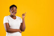 © Prostock-studio - Cheerful African Woman Pointing Finger Up Having Idea, Yellow Background