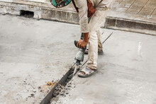 Construction Worker Using Jackhammer Drilling Concrete Surface
