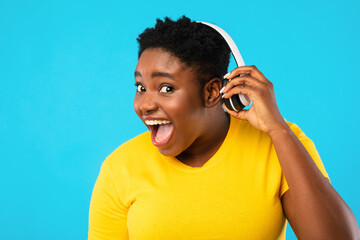 Wall Mural - Funny Black Woman Taking Off Headphones Listening Music, Blue Background