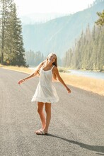 Woman Walking On The Road In A Sun Dress