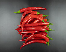 A Bunch Of Red Chili Peppers On A Black Background, Top View
