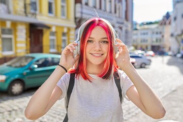 Wall Mural - Outdoor portrait of teenage girl listening music with wireless headphones