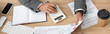 © LIGHTFIELD STUDIOS - partial view of trader working with calculator and infographics near notebook and coffee to go, banner