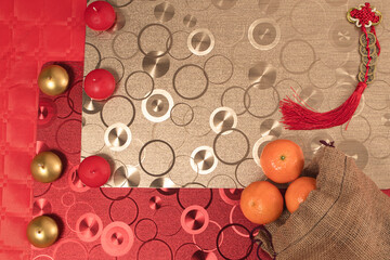 Chinese new year arrangement with table and red background with red and silver decorations, tablecloths and tangerines