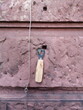 Flaschenöffner an einer Schraube in einer rötlichen Sandsteinfassade hängend vor einem Café im Nordend von Frankfurt am Main in Hessen