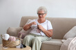 © New Africa - Elderly woman crocheting at home. Creative hobby