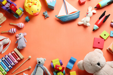 Wall Mural - Frame made of different toys on orange background, flat lay. Space for text