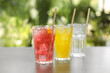 © New Africa - Delicious refreshing drinks in glasses on grey table outdoors
