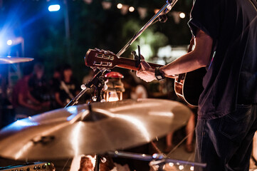 The musicians were playing rock music on stage, there was an audience full of people watching the concert. Concert,mini concert and music festivals.