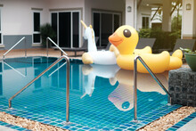 Stair On Swimming Pool With Blurred Inflatable Yellow Duck, Holiday On Summer Fun Party In Pool Villa
