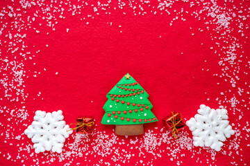 Top view of snowflakes, Christmas tree on red background. Minimal concept of New year and Christmas. Flat lay.