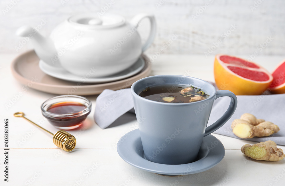 Cup of aromatic tea with lemon, honey and ginger on table